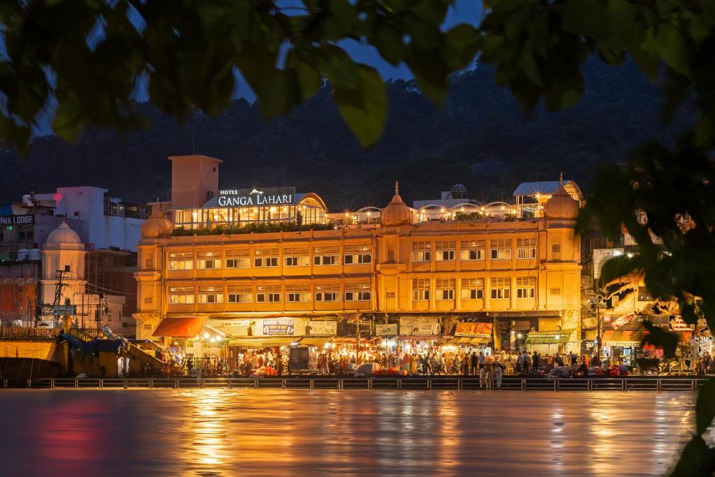 un gran edificio frente a una ciudad por la noche en Ganga Lahari by Leisure Hotels en Haridwār
