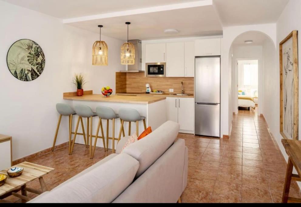 ein Wohnzimmer mit einem Sofa und einer Küche in der Unterkunft Apartamento Jaira in Playa Honda