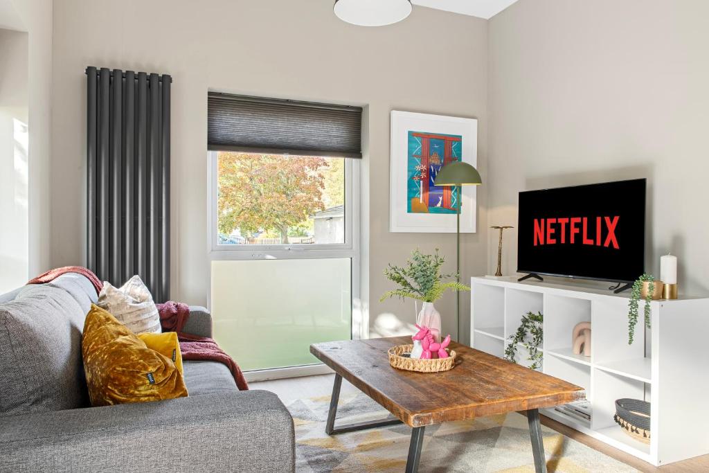 uma sala de estar com um sofá e uma televisão em Brand New 1-Bed Flat With Free Parking em Nottingham