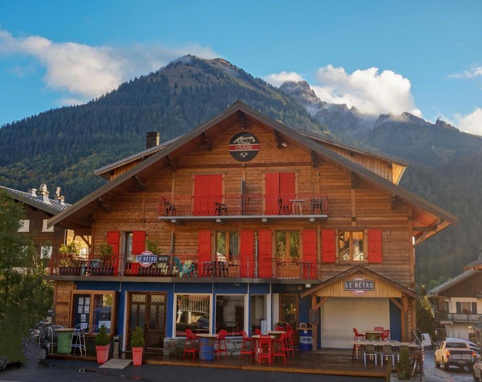 un edificio de madera con puertas rojas y balcón en Le Rétro, en La Chapelle-dʼAbondance