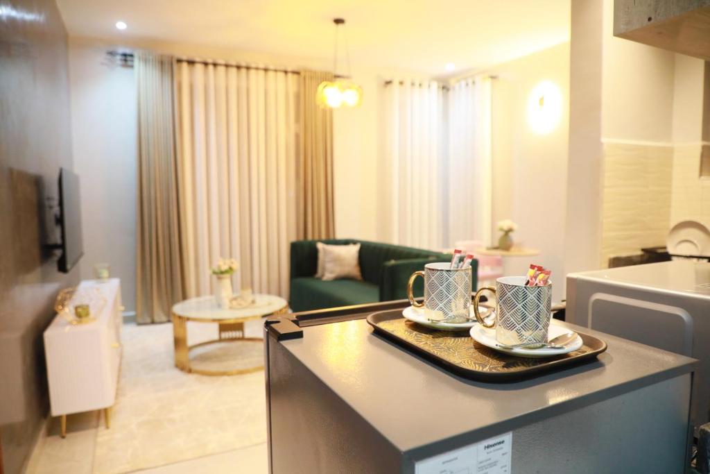 uma cozinha e sala de estar com uma mesa com duas chávenas em Emerald House - Modish- Great Views - Backup Power - Wifi - Smart TV em Kampala