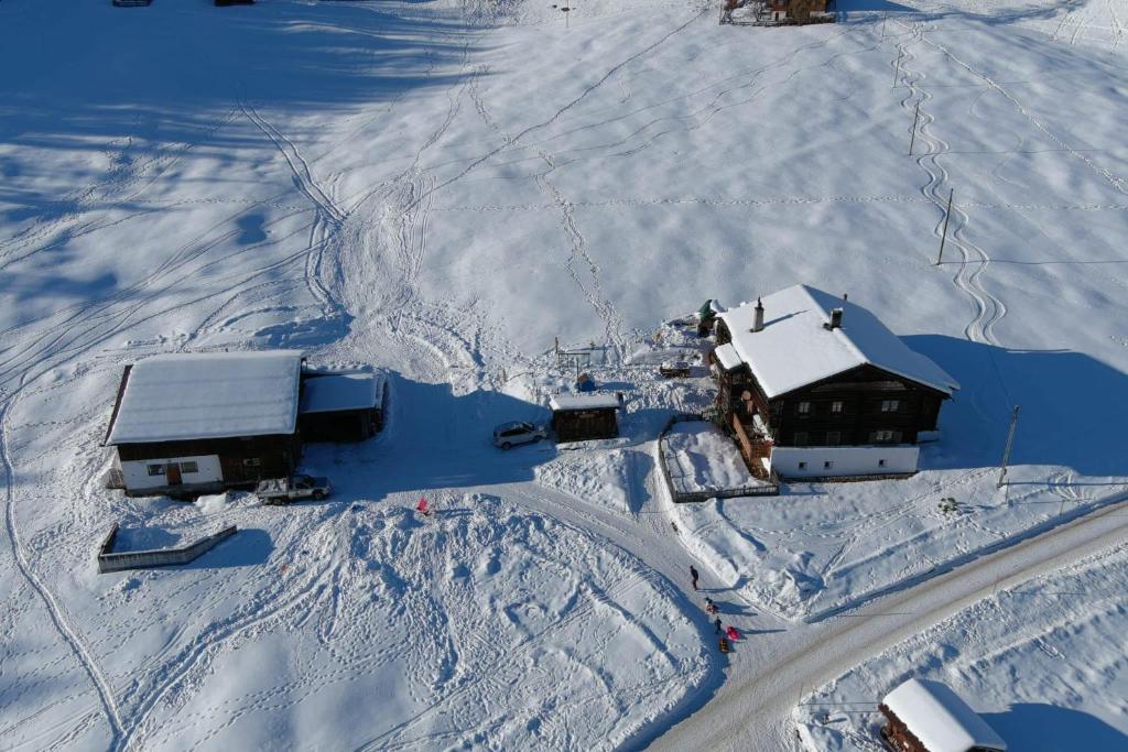 una vista aérea de una casa en la nieve en Idyllisch gelegene grosszügige Ferienwohnung Chumma en Frauenkirch