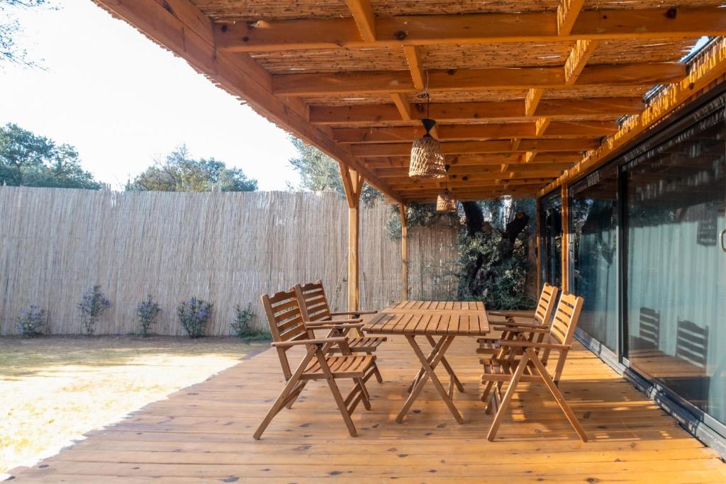 une terrasse en bois avec une table et des chaises. dans l'établissement Bungalow with Garden 10 min to Shore in Fethiye, à Fethiye
