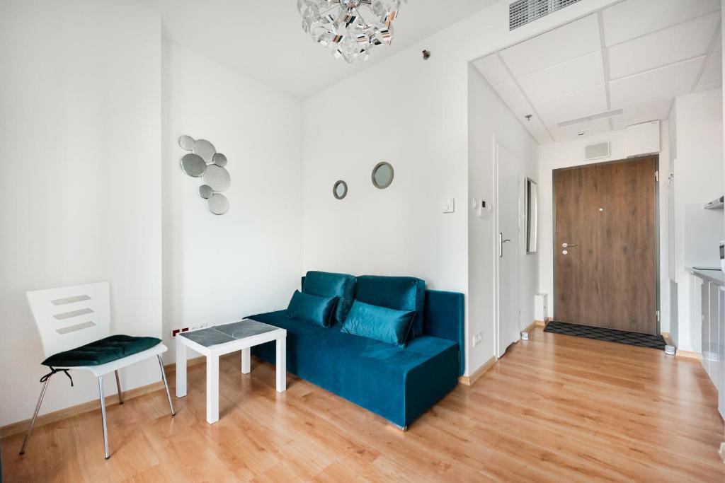 a living room with a blue couch and a table at New Varsovia Comfort 310 in Warsaw