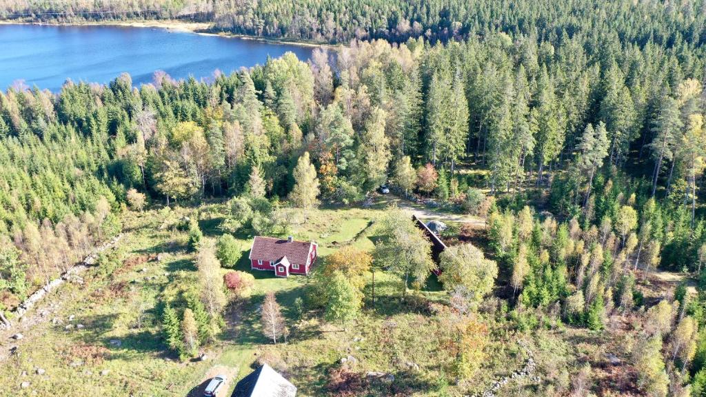 een luchtzicht op een huis op een heuvel naast een meer bij Holiday home Småland Siggamåla in Husjönäs