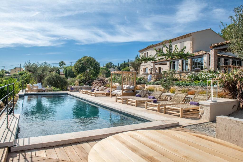 - une piscine avec des chaises et une maison dans l'établissement LA BASTIDE DES CULS-ROUSSET, à Marseille