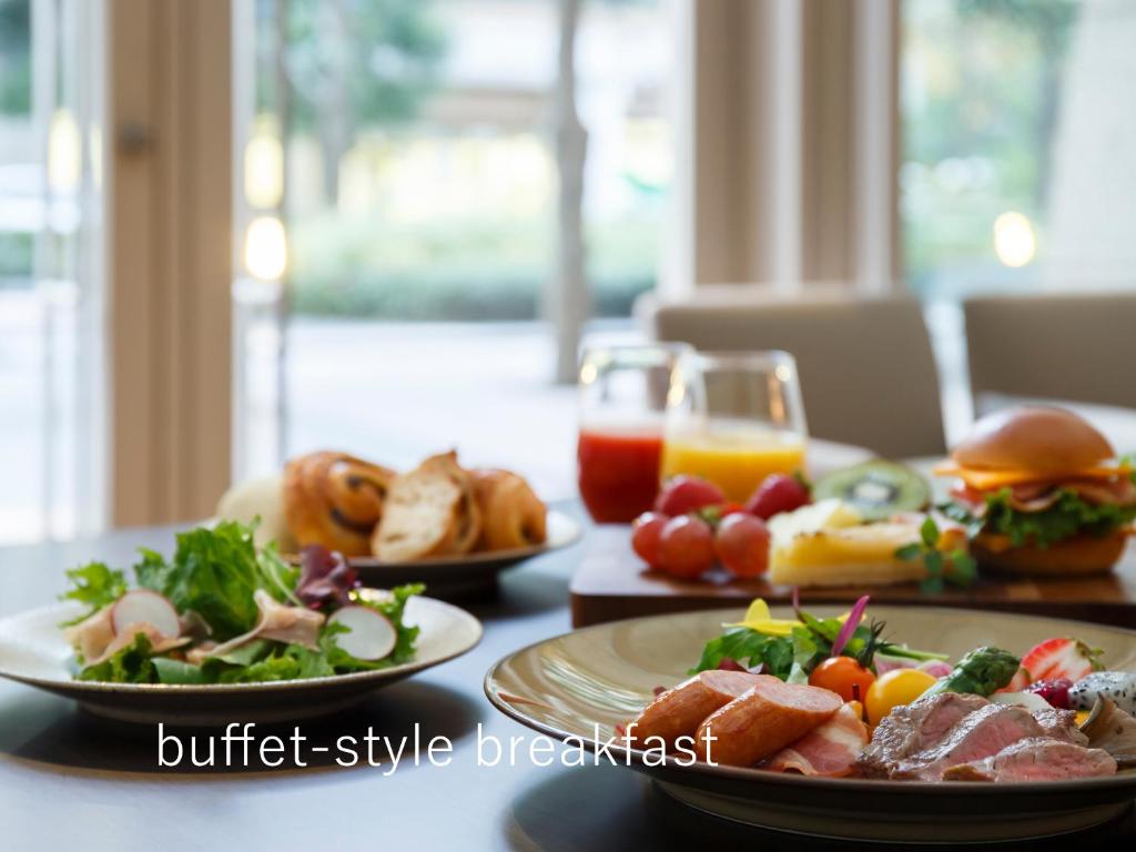 a table with plates of food and a glass of orange juice at Hotel The Celestine Tokyo Shiba in Tokyo