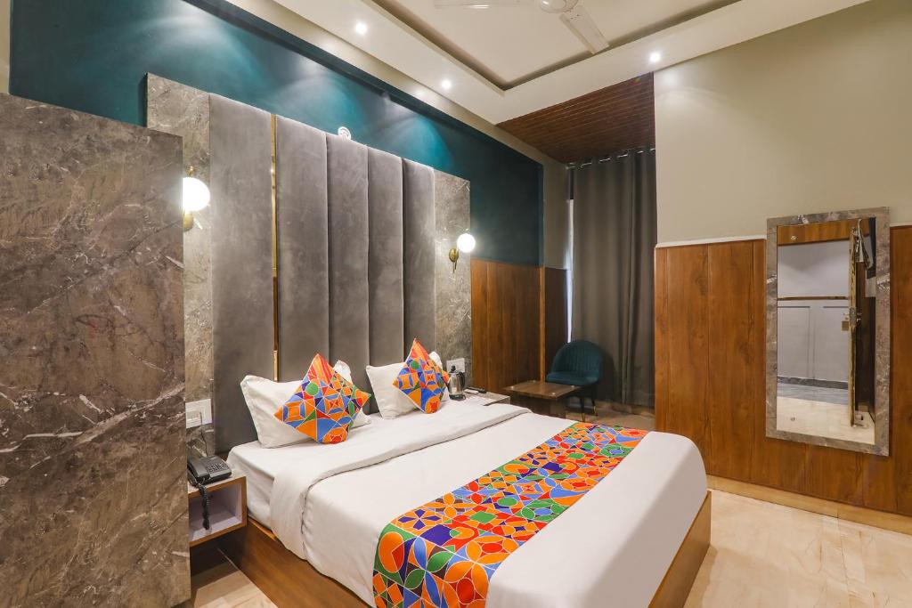 ein Schlafzimmer mit einem großen Bett mit bunten Kissen in der Unterkunft FabHotel Royal Palm Inn in Faizābād