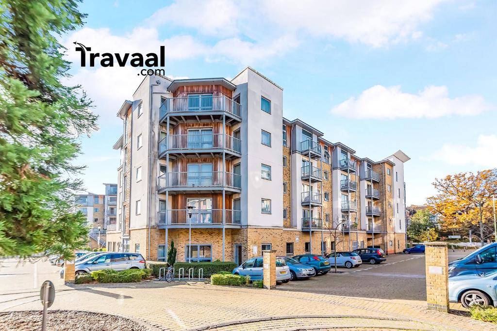 an apartment building with cars parked in a parking lot at Travaal.©om - 2 Bed Serviced Apartment Farnborough in Farnborough