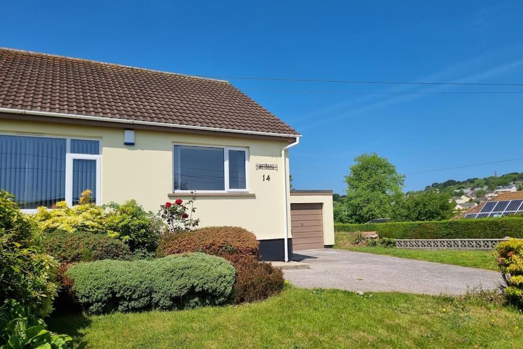 a white house with a driveway and bushes at Cornish Village Getaway in Gwennap