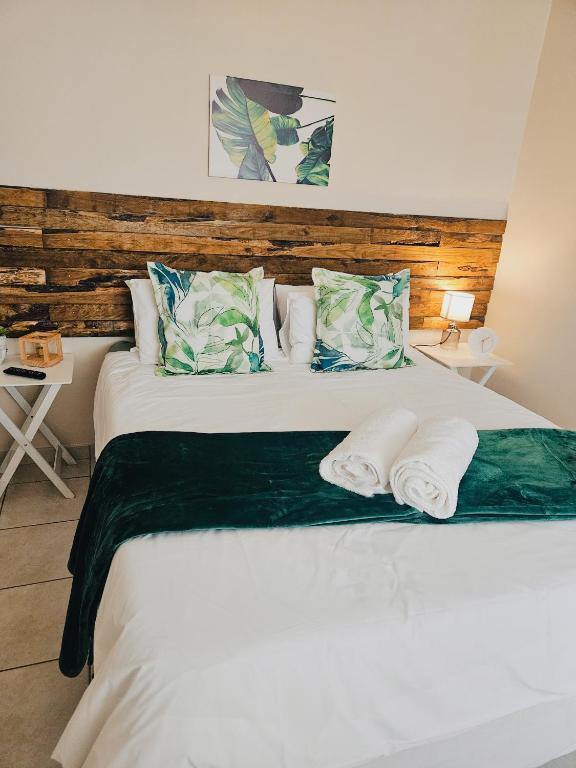 a bedroom with a large white bed with two pillows at Sea Breeze Manor - Green Unit in East London