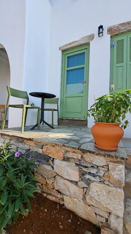 um pátio com uma porta verde, uma mesa e cadeiras em Spice Suites-Lime em Amorgós