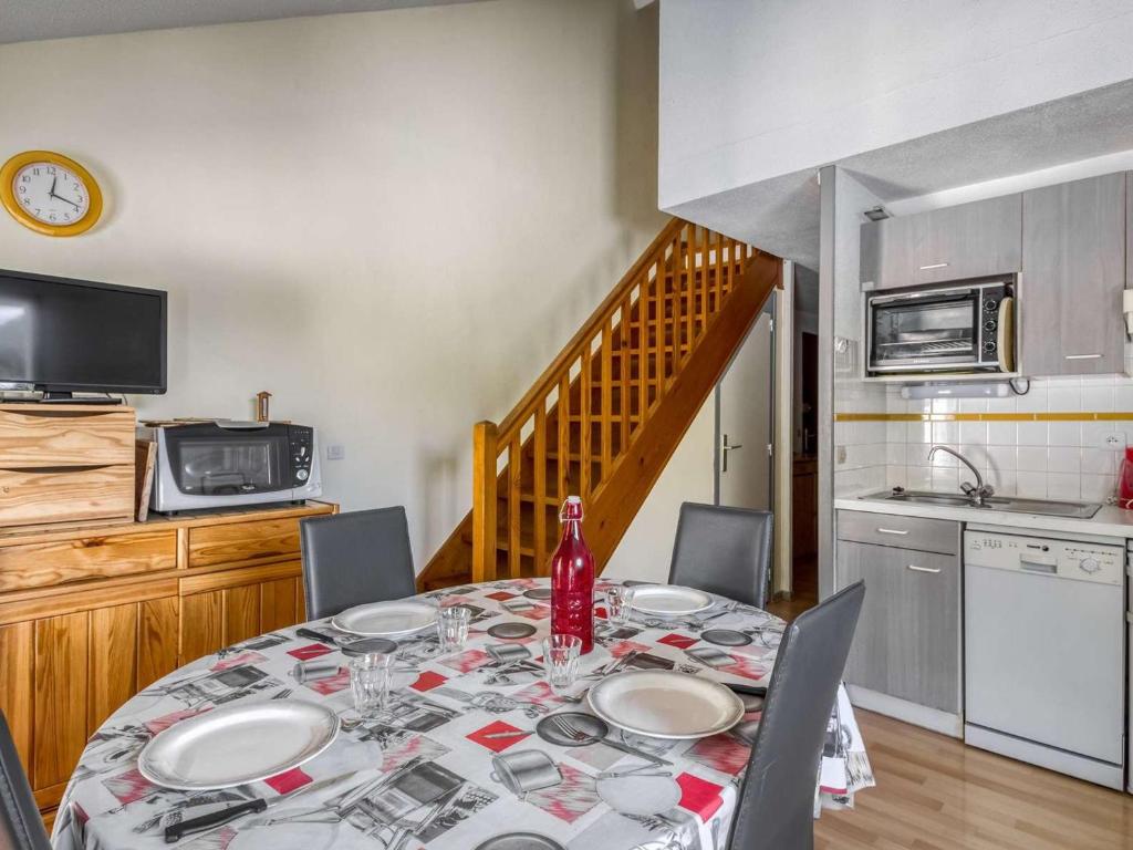 une table de salle à manger avec des chaises et une cuisine dans l'établissement Duplex cosy 6 pers, 2 ch, balcon, parking, près des pistes à Barèges - FR-1-403-9, à Barèges