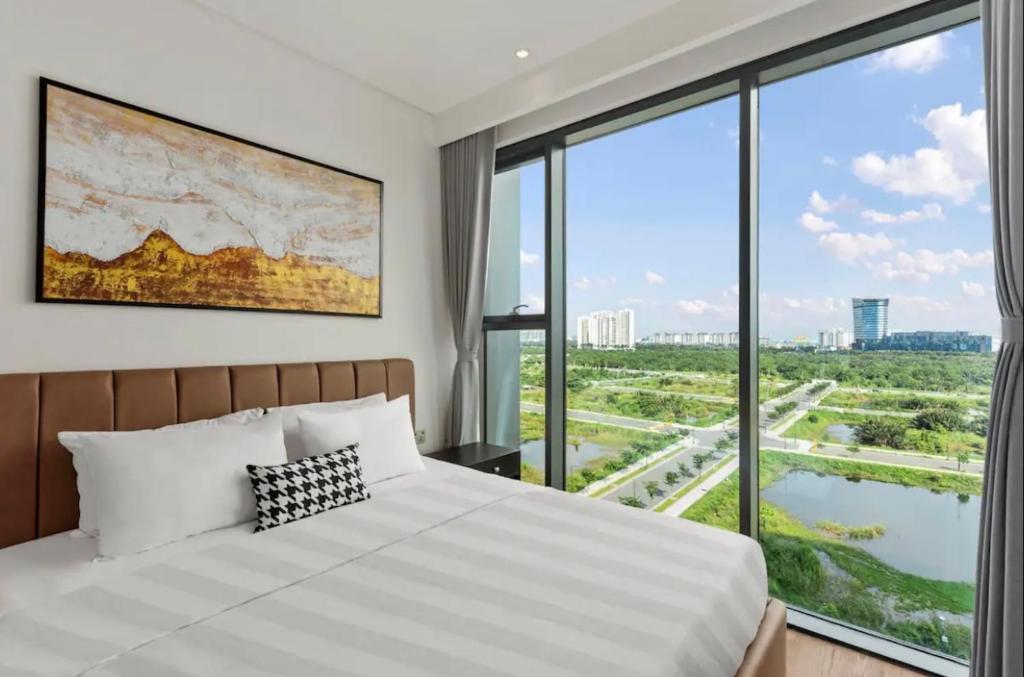 um quarto com uma cama e uma grande janela em THE CREST-Central Saigon Riverside -Free POOL-GYM-SAUNA Room-YOGA Room em Cidade de Ho Chi Minh