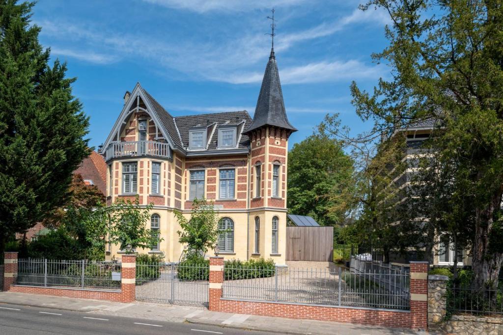 a large house with a turret on a street at Bella vista in Valkenburg