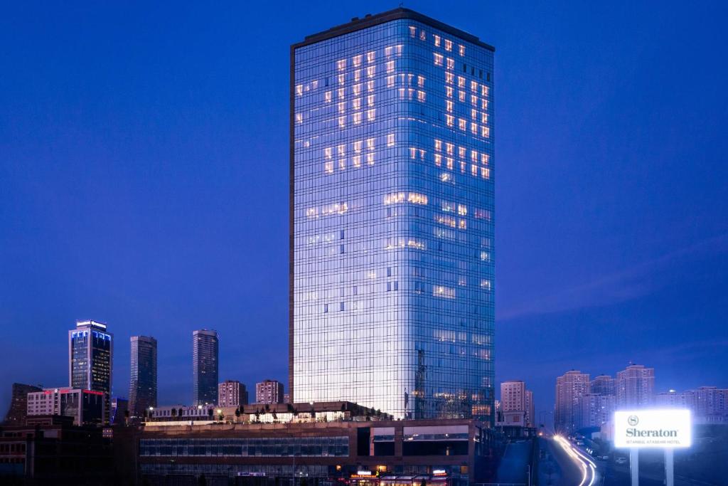 a tall glass building with lights on it in a city at Sheraton Grand Istanbul Atasehir in Istanbul