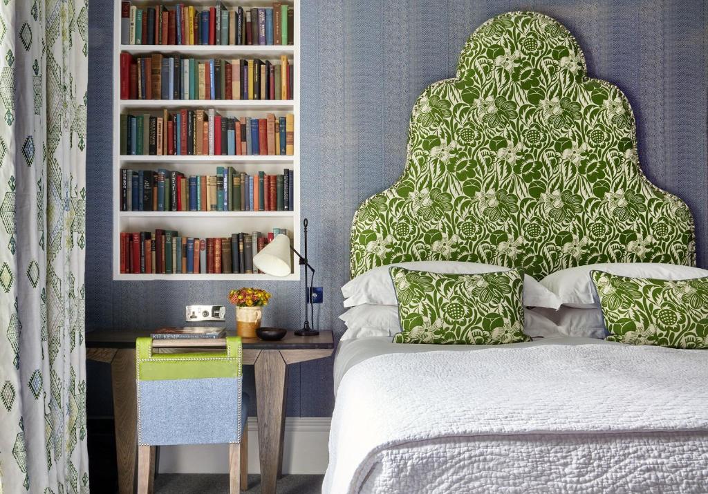ein Schlafzimmer mit einem Bett und einem Bücherregal mit Büchern in der Unterkunft Number Sixteen, Firmdale Hotels in London