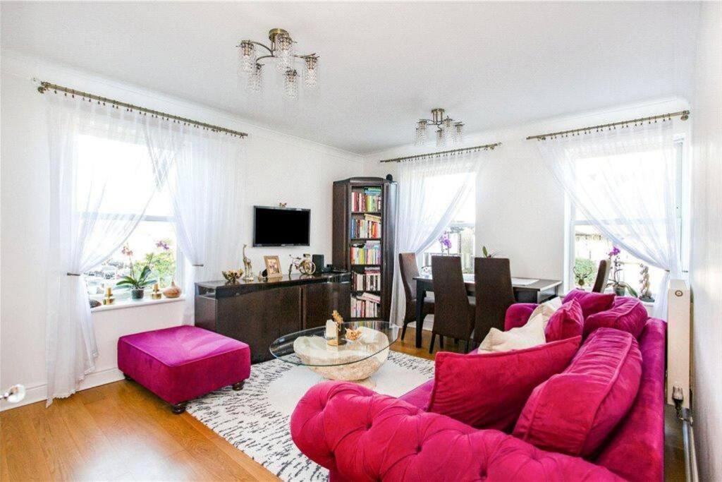 a living room with a pink couch and a table at Lovely 1 bedroom flat in Richmond-great location! in Richmond upon Thames