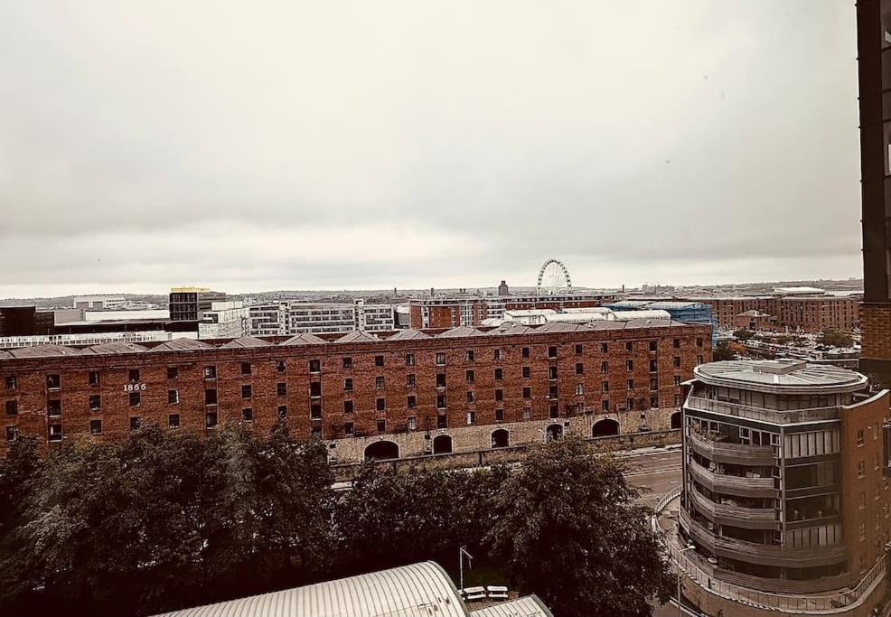 a large brick building with a train in a city at BRAND NEW 5 STAR LUXURY 2 BEDROOM APARTMENT, SLEEPS 6, CENTRAL, WiFI, BIG SMART TV, ALEXA SPEAKERS, EASY ACCESS LOCK BOX ENTRY! in Liverpool
