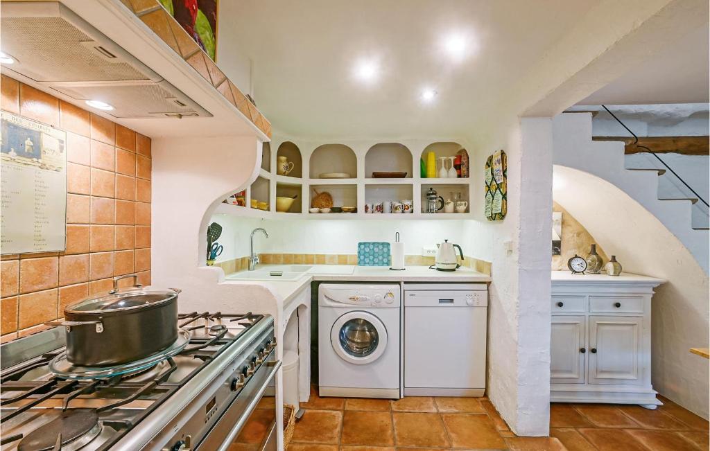 a kitchen with a stove and a washing machine at Awesome Home In Fontarches With 2 Bedrooms, Wifi And Outdoor Swimming Pool in Fontarèches