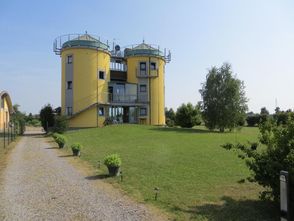a large yellow building on a grassy field at I Silos Guest house in Seriate