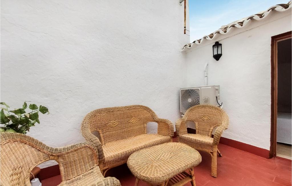 Zimmer mit Korbstühlen, einem Tisch und einem TV in der Unterkunft Lovely Home In Olvera With Wi-fi in Olvera