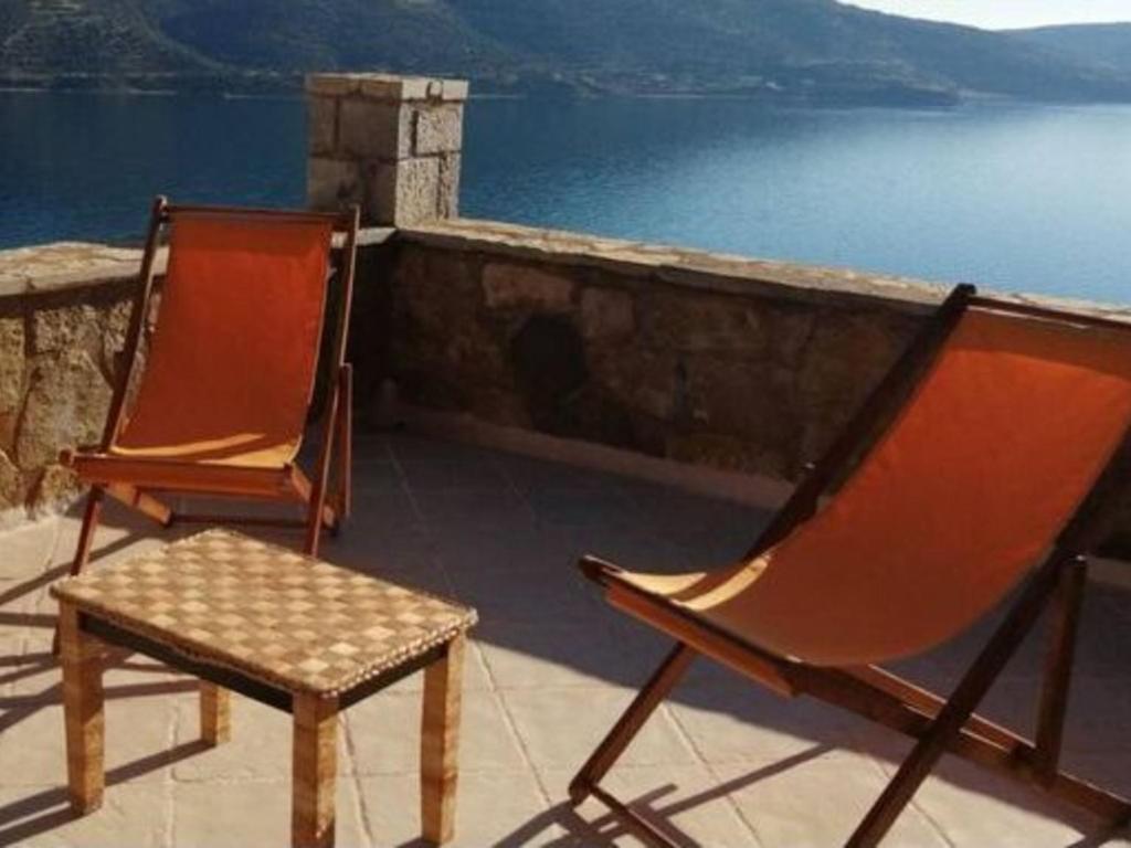dwa krzesła siedzące na balkonie z widokiem na wodę w obiekcie Cozy Apollon Villa, Sea View, Next To Galaxidi w mieście Eratini