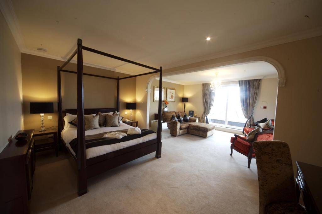 una camera con letto a baldacchino e un soggiorno di The Fairview Boutique Hotel a Killarney