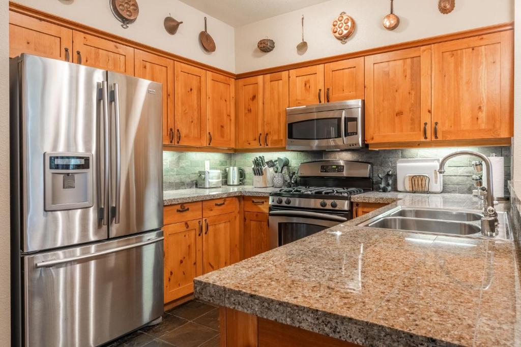 eine Küche mit Holzschränken und einem Edelstahlkühlschrank in der Unterkunft Cabins 1 in Mammoth Lakes