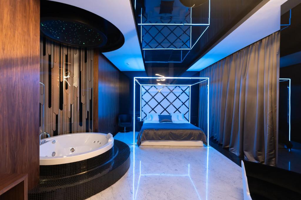 ein Bad mit einer Badewanne und einem Bett darin in der Unterkunft Tsarsky Hotel in Kiew