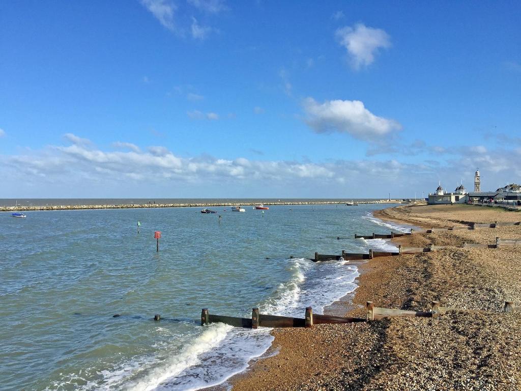 a beach with a shoreline with boats in the water at Kiranchiyampathy in Goodnestone