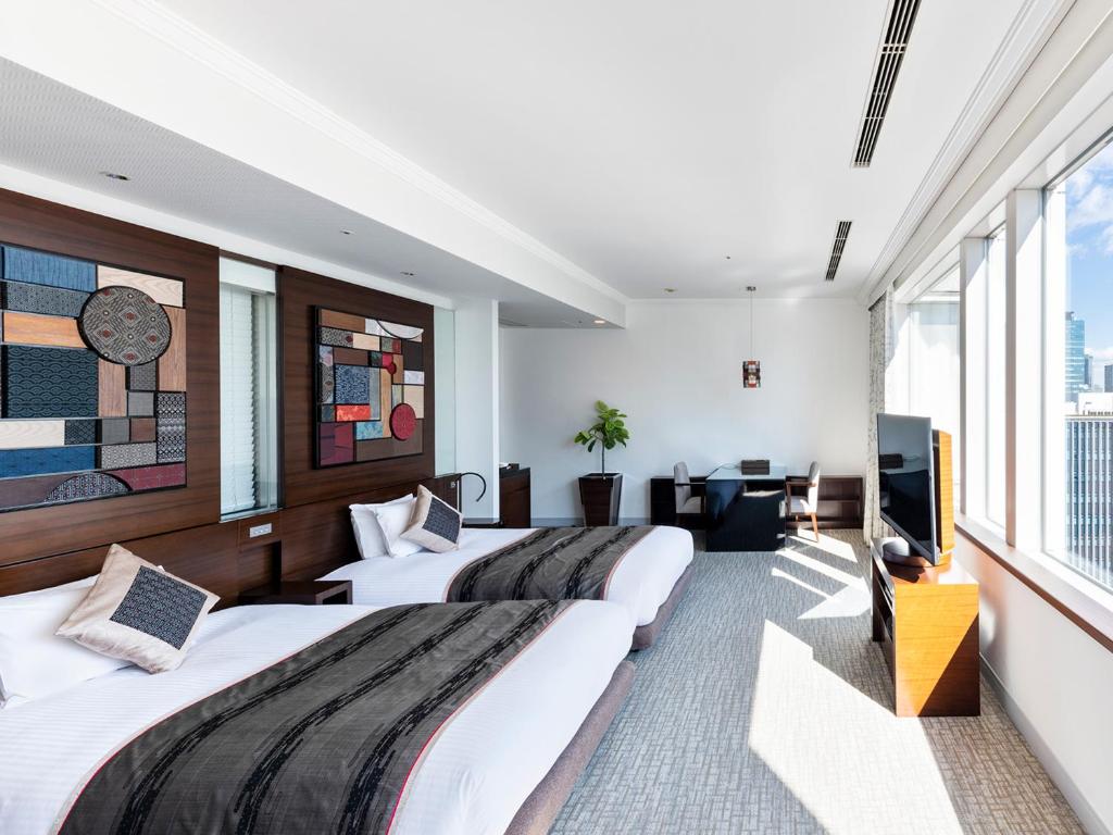 a hotel room with three beds and a flat screen tv at Hotel The Celestine Tokyo Shiba in Tokyo