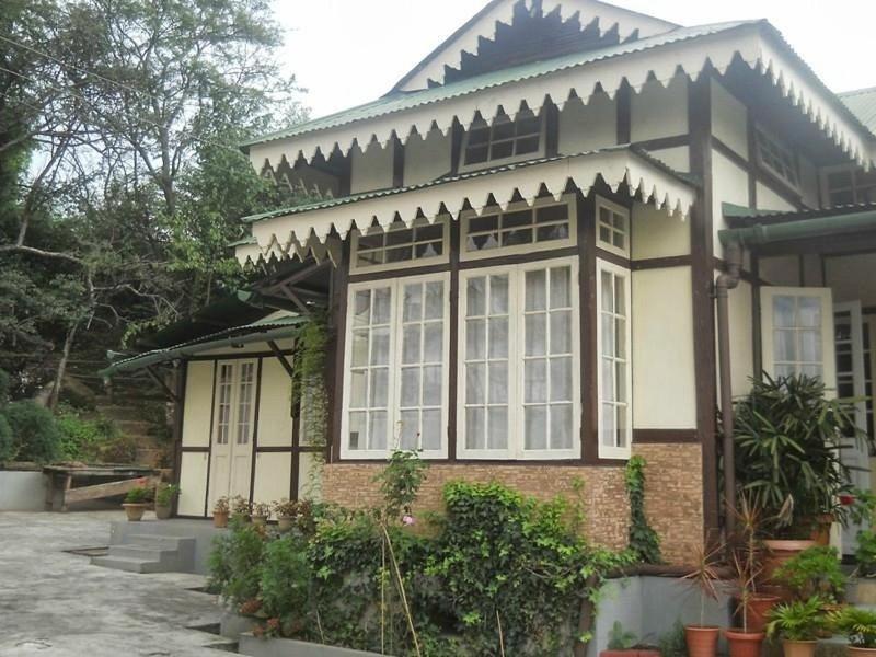 a house with a lot of windows on it at Cafe Shillong Bed and Breakfast in Shillong
