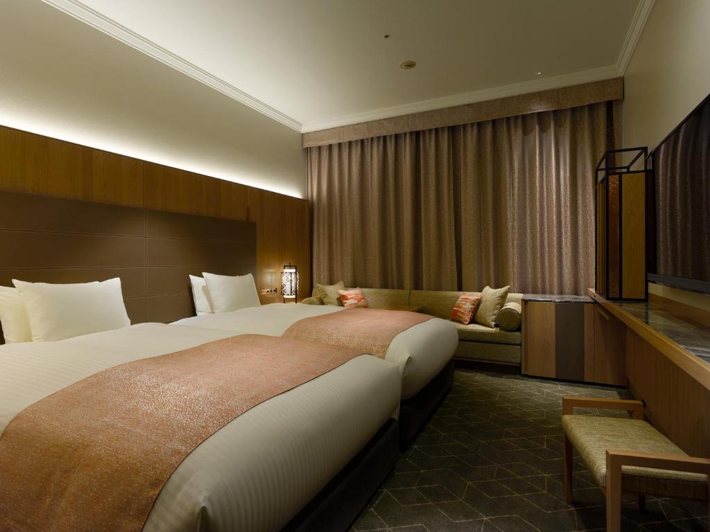a hotel room with a large bed and a couch at Hotel The Celestine Tokyo Shiba in Tokyo
