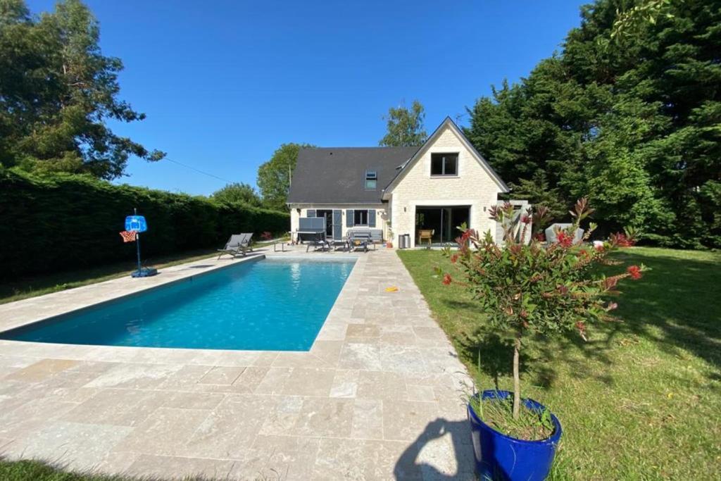 uma casa com piscina em frente a uma casa em Villa Giulia - Maison avec Piscine - Bonneville-Sur-Touques em Bonneville-sur-Touques