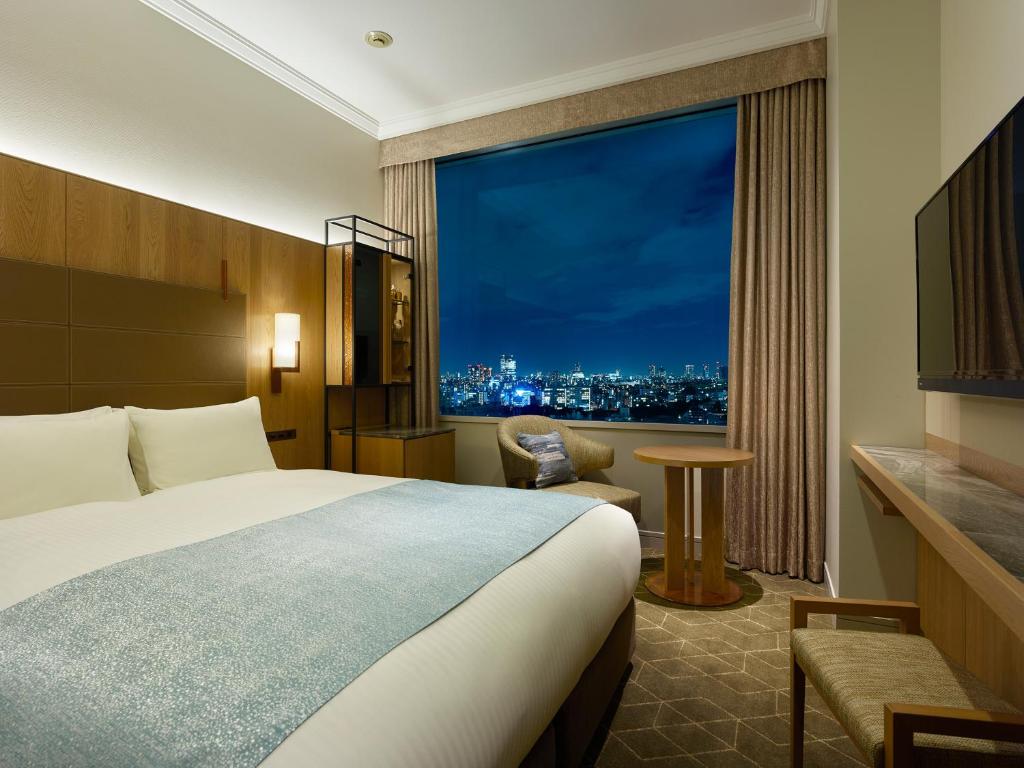 a hotel room with a bed and a large window at Hotel The Celestine Tokyo Shiba in Tokyo