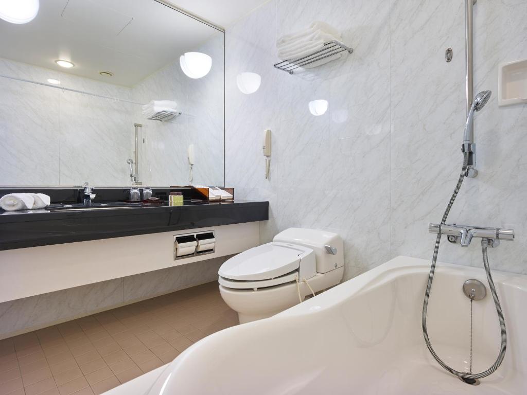 a bathroom with a tub and a toilet and a sink at Hotel The Celestine Tokyo Shiba in Tokyo