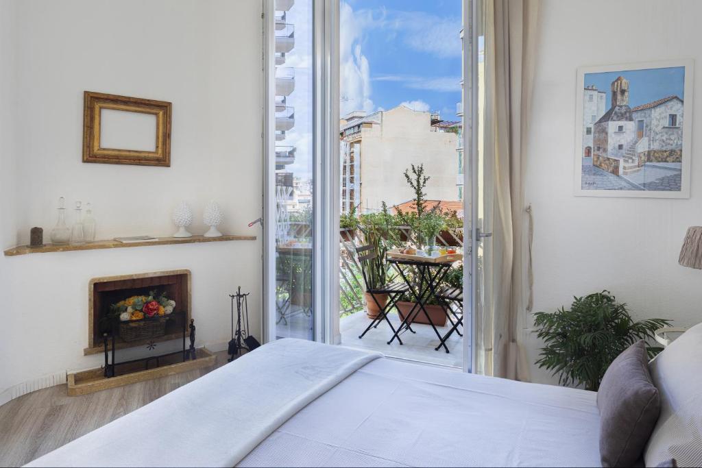a bedroom with a bed and a large window at Le case di Frelli in Palermo