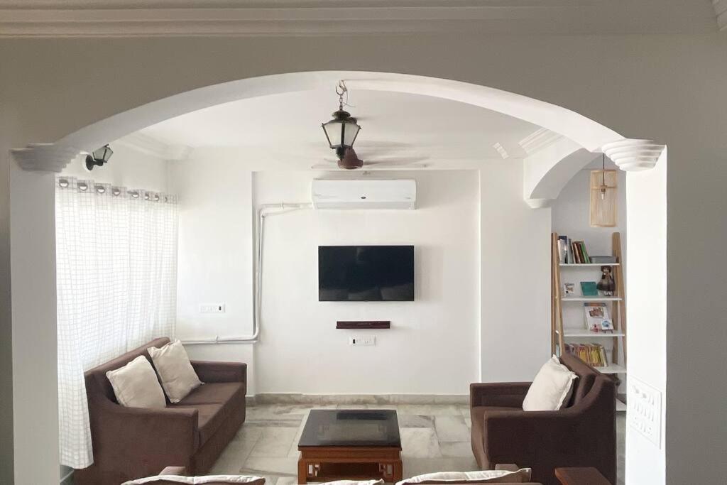 ein Wohnzimmer mit einem Sofa und einem TV in der Unterkunft 3BHK Duplex Service Apartment near Riverfront in Ahmedabad