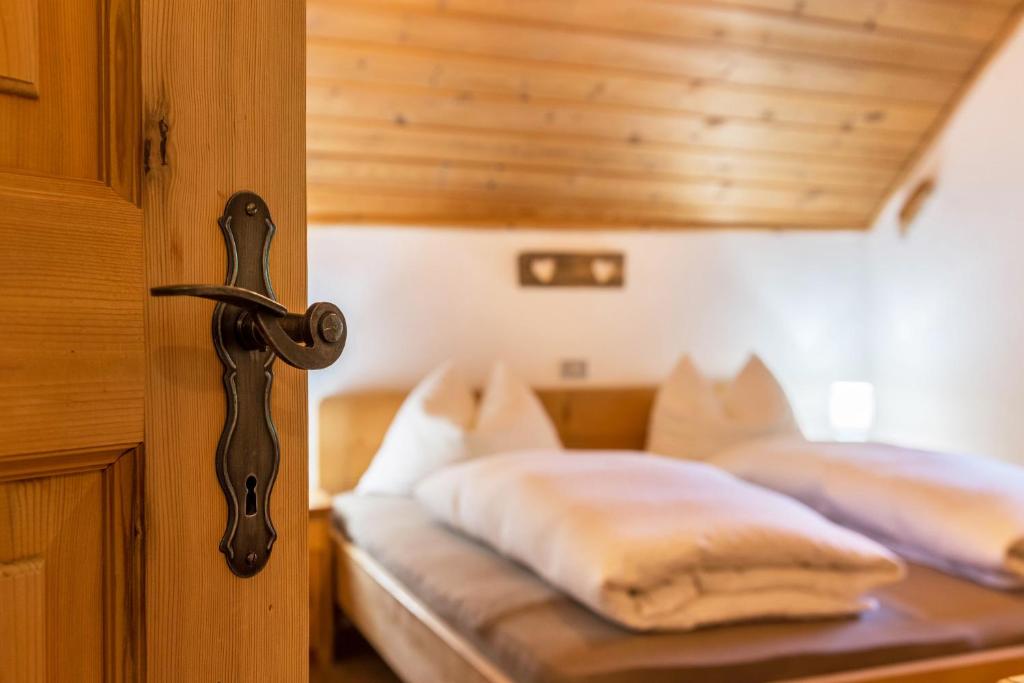 Un dormitorio con una cama con sábanas blancas. en Ronacherhof Apt Ringelblume, en Auna di Sopra