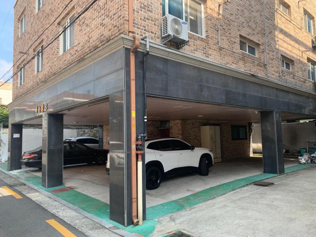 un garage con una macchina bianca parcheggiata in esso di Miranda House a Jeonju