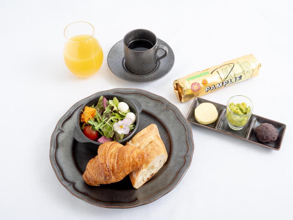 a breakfast plate of bread and a salad and a cup of orange juice at Hotel The Celestine Tokyo Shiba in Tokyo