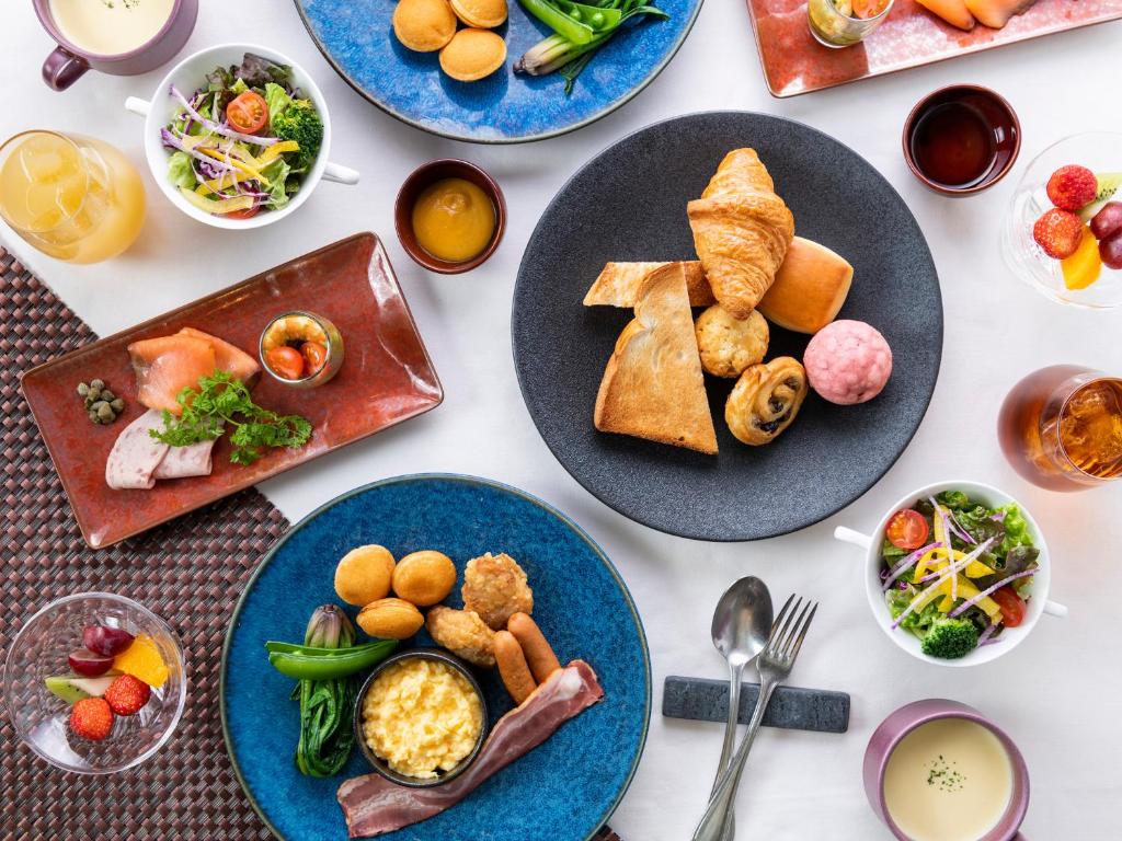 a white table with plates of food on it at Hotel The Celestine Tokyo Shiba in Tokyo