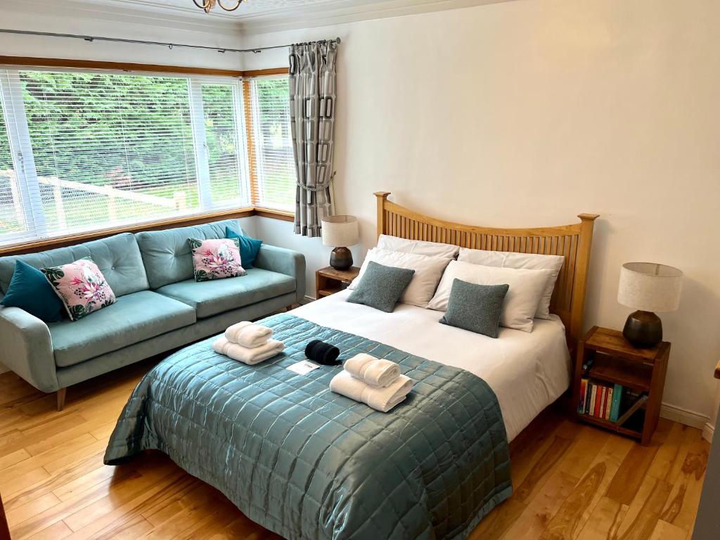 a bedroom with a bed and a couch at The Annexe at Cluny House in Inverness