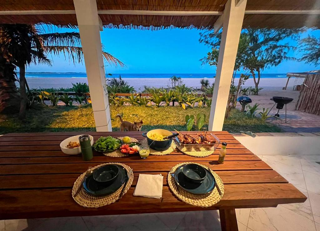 einen Tisch mit Essen und Blick auf den Strand in der Unterkunft Casa do Índico in Praia do Tofo