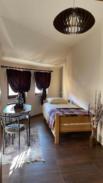 een slaapkamer met een bed, een bureau en een tafel bij n'Bjeshke te Guri i Zi in Dragash