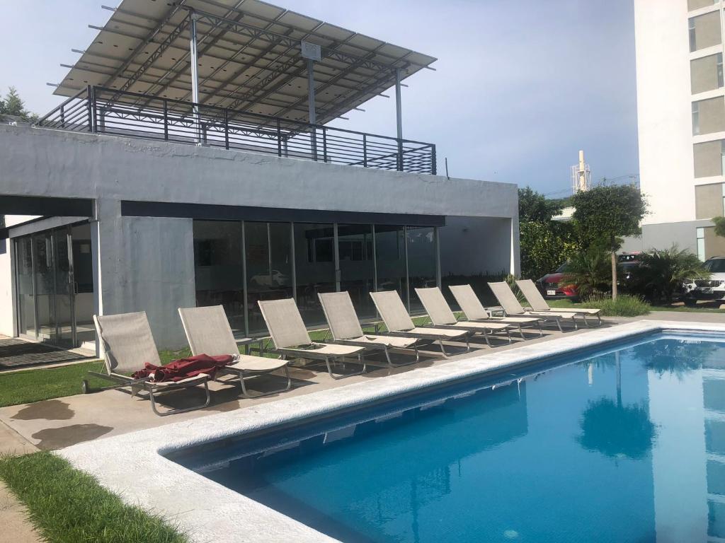una piscina con tumbonas y un edificio en Departamento de lujo exclusivo vistas y literas, en Guadalajara