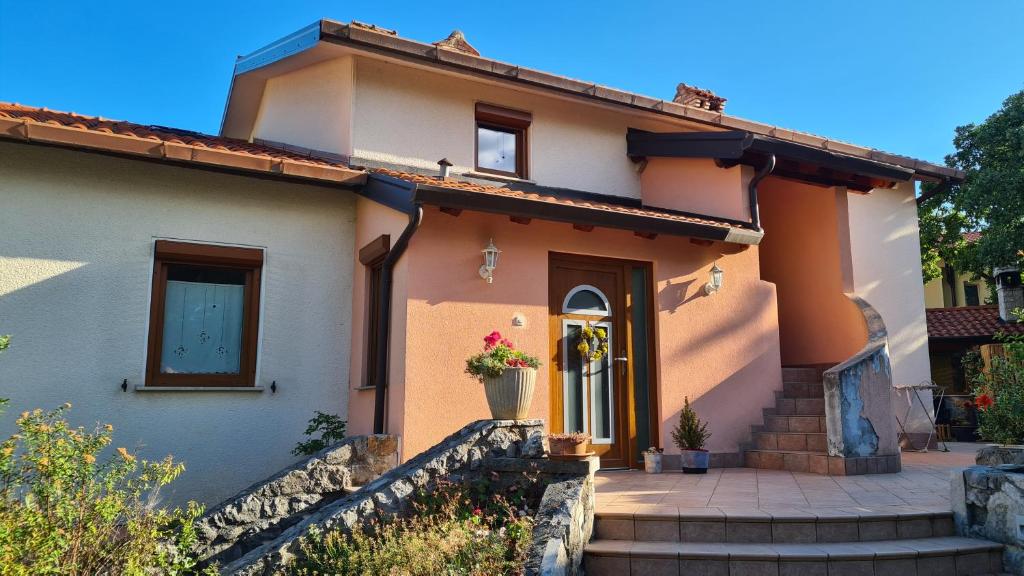 una casa con una puerta principal y escaleras en Attic apartment with a terrace, en Sežana