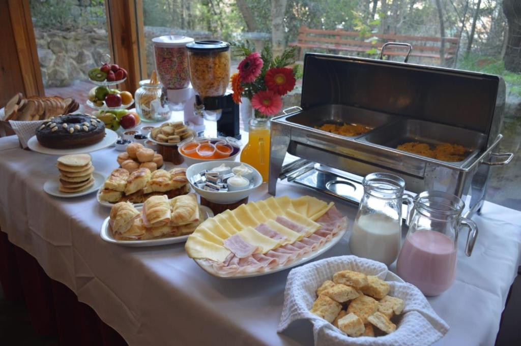 stół z talerzami jedzenia i grillem w obiekcie Villa Sofía Apart Hotel w mieście Bariloche