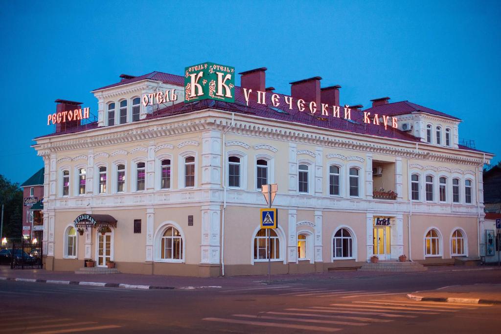 a white building with a sign on top of it at Kupecheskiy Club Hotel in Bor